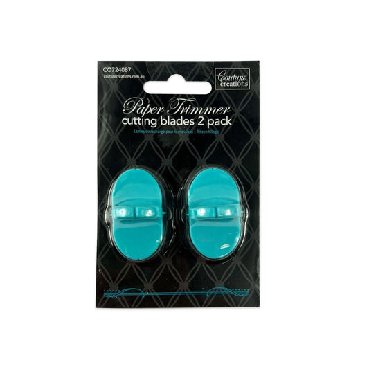Pack of two teal paper trimmer blades in clear plastic on a black background with 'Couture Creations' branding.