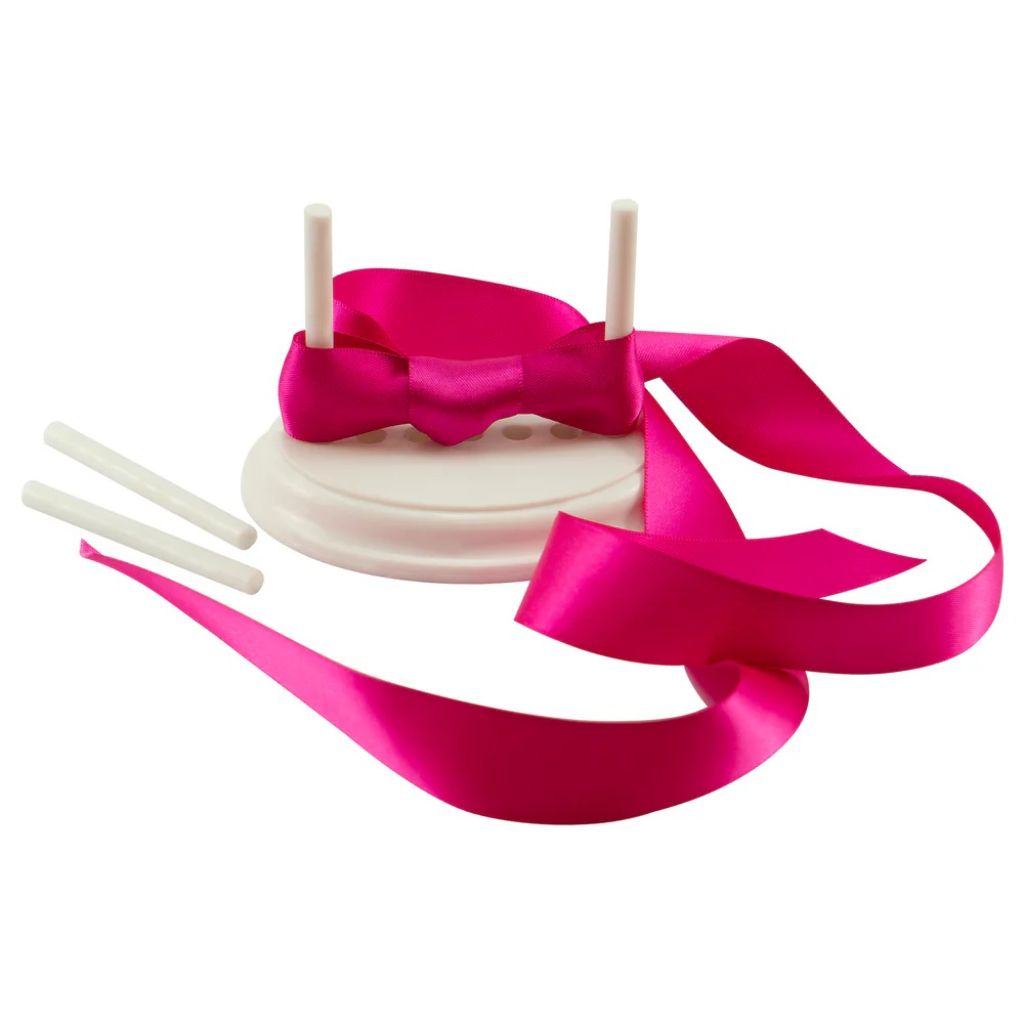 Couture Creations ribbon frame bow maker with hot pink satin bow and white oval base with 4 adjustable pillars