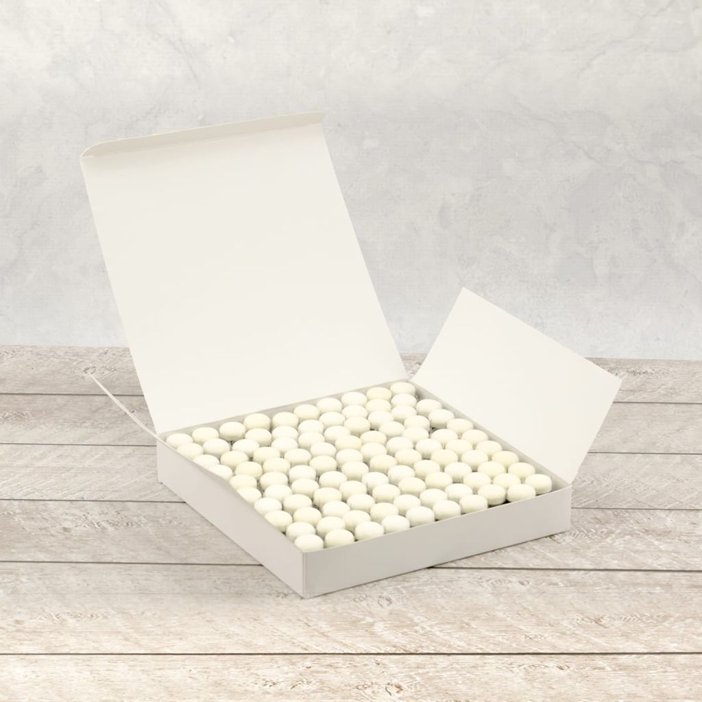 Open box filled with white sponge daubers on a wooden surface.