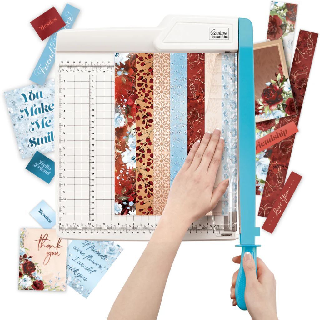 12x12 Paper Guillotine Trimmer with a person's hands cutting patterned scrapbooking papers. 