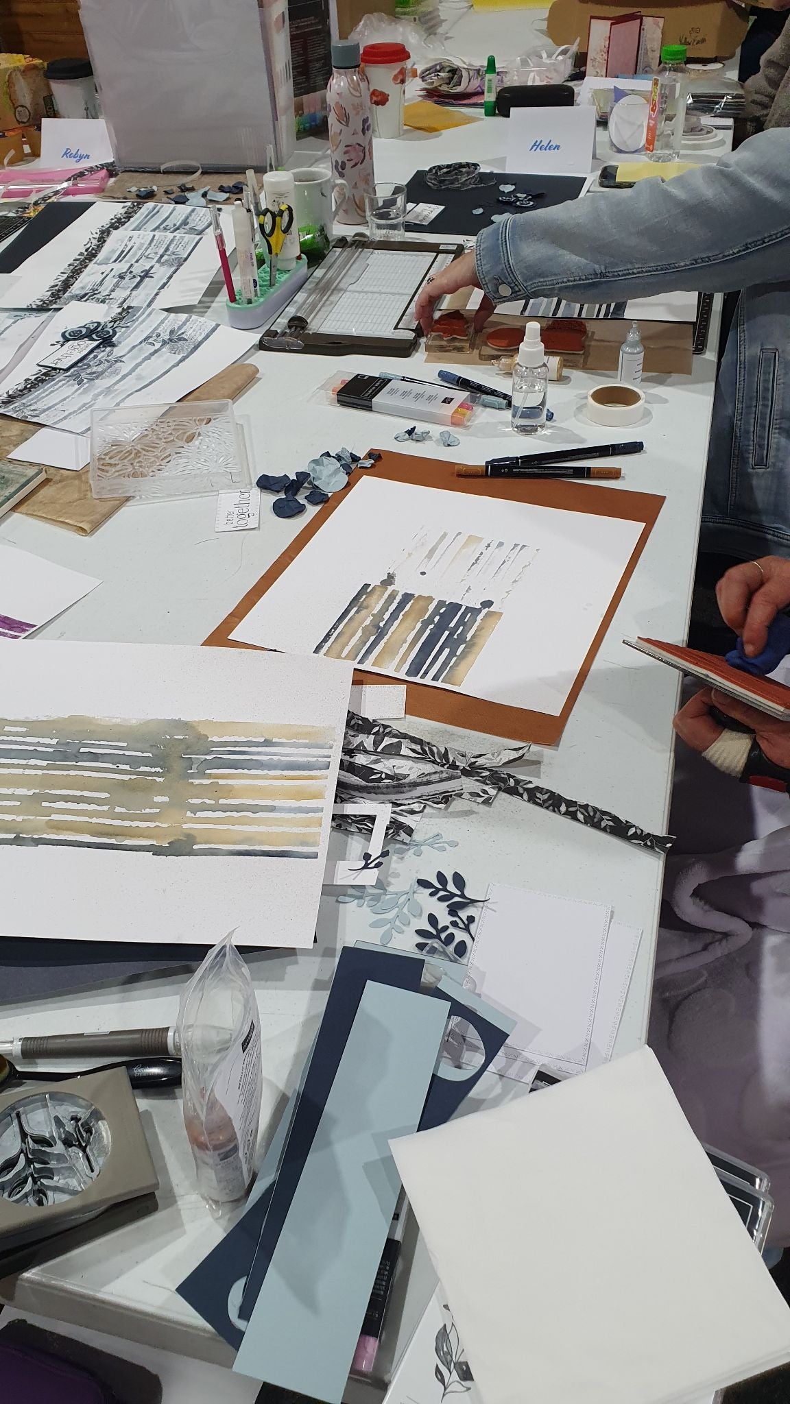 Crafter using stamps and inks to create scrapbook pages at a creative retreat workshop in Victoria