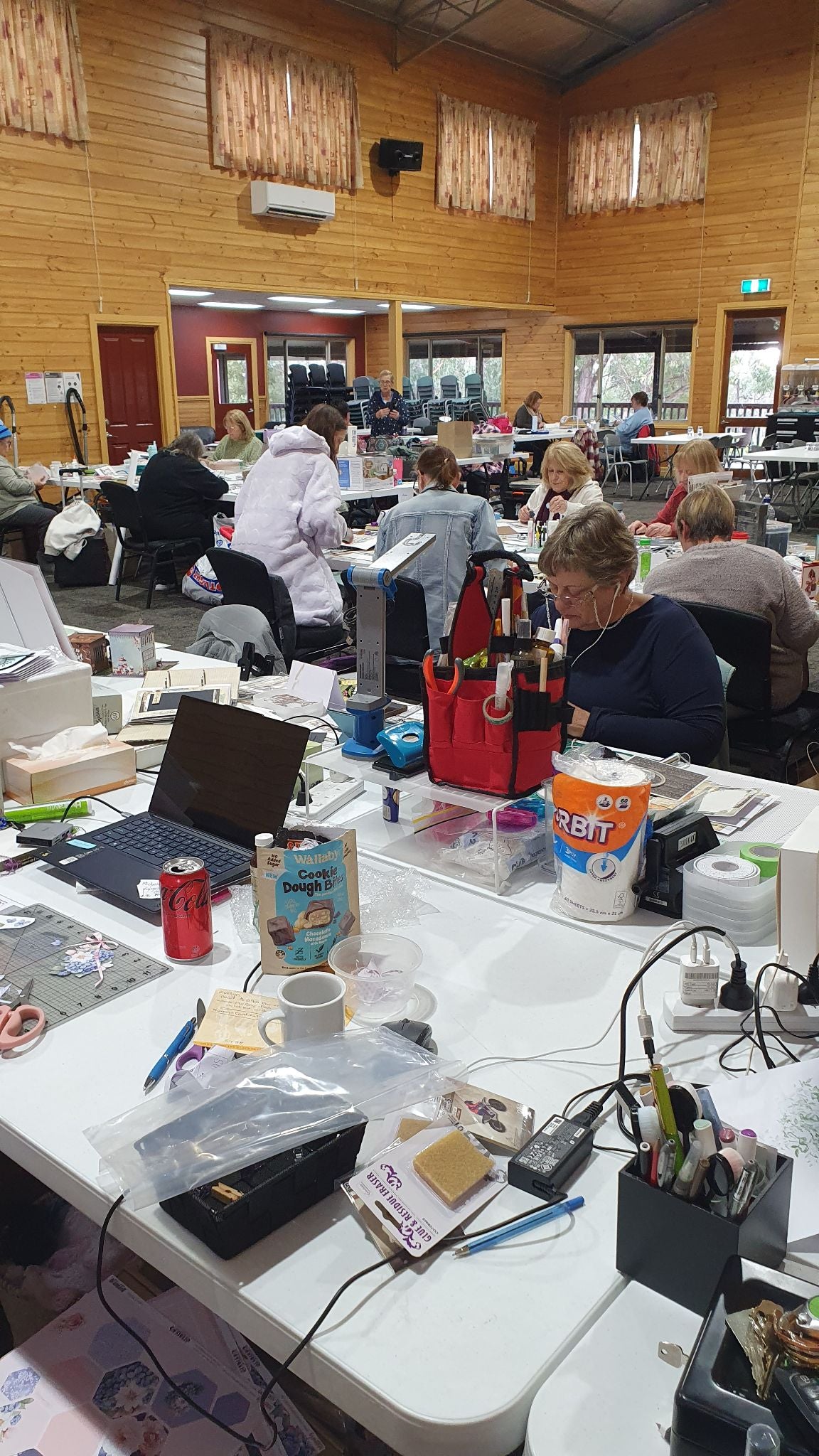 Close-up of crafter's workspace showing paper crafting supplies, tools and projects at all-inclusive creative retreat Victoria