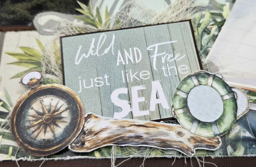 Close-up of Beachside Life scrapbook kit fussy cut embellishments including compass, driftwood and life ring