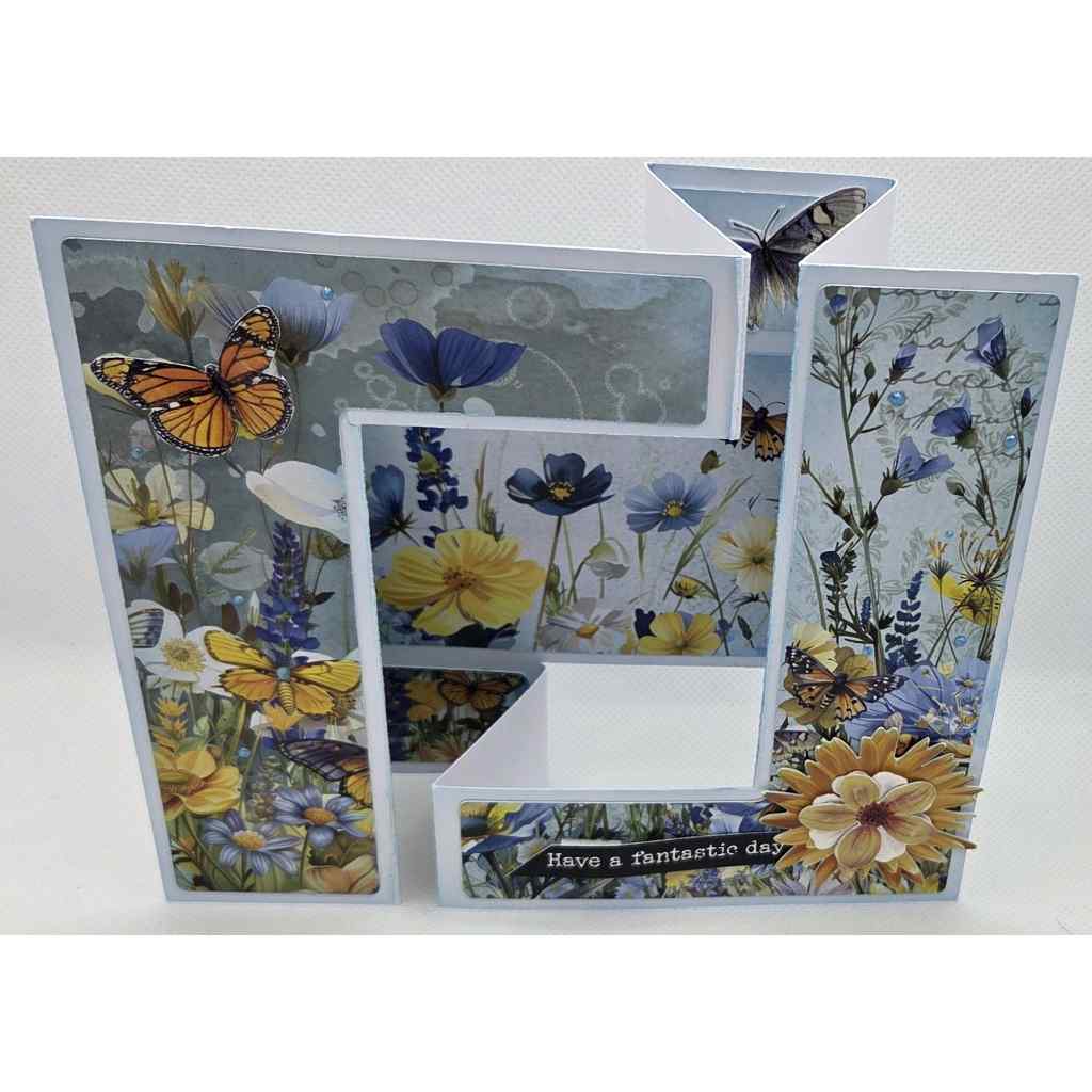 Honey Fields Double Z fold card featuring butterfly and wildflower fussy cut embellishments on a soft blue background