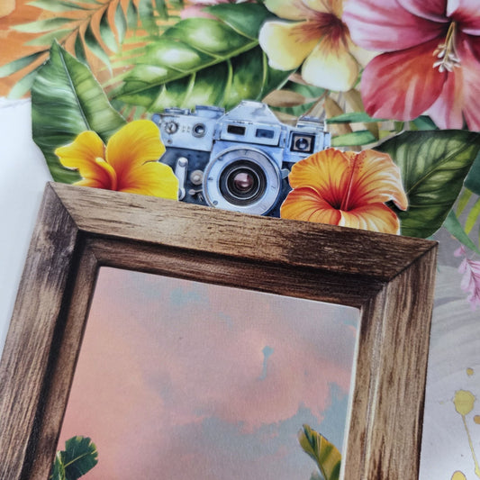 Close-up of rustic wooden frame accent with vintage camera die-cut and yellow and orange hibiscus flowers from the Tropical Excursion layout kit