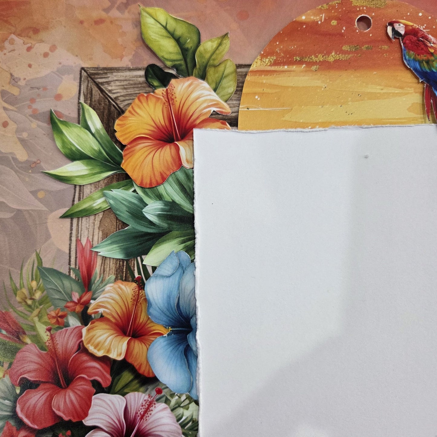 Detail of Tropical Excursion scrapbook layout showing layered hibiscus florals, parrot embellishment and sunset tag on warm terracotta background