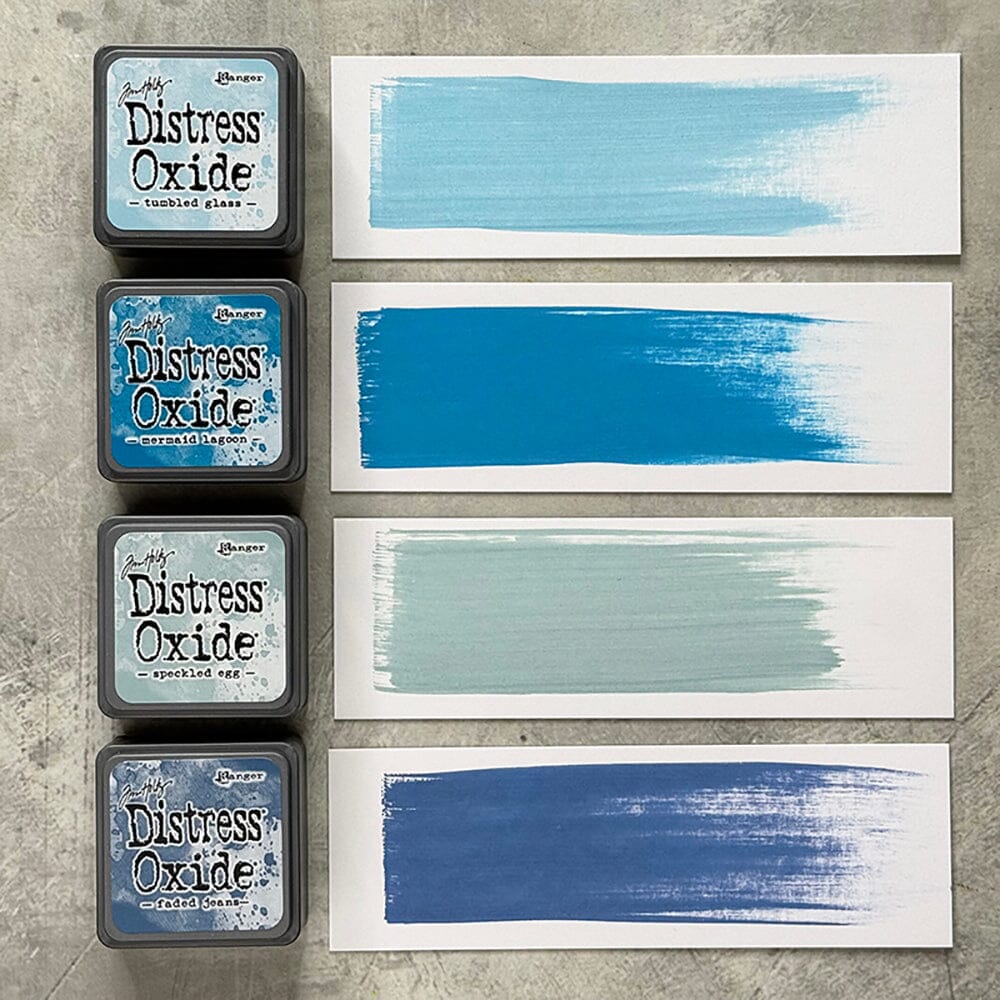 Four Ranger Distress Oxide ink pads from Kit 10 with swatched colours: Speckled Egg, Tumbled Glass, Mermaid Lagoon and Faded Jeans, shown on white paper beside each labelled pad.
