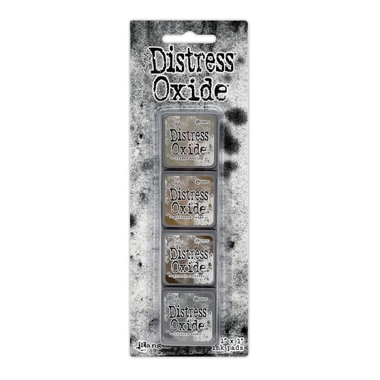 Packaged set of four Ranger Distress Oxide Mini Ink Pads from Kit 12 in Frayed Burlap, Gathered Twigs, Ground Espresso and Hickory Smoke, shown in original Tim Holtz packaging with grungy black-and-white background.
