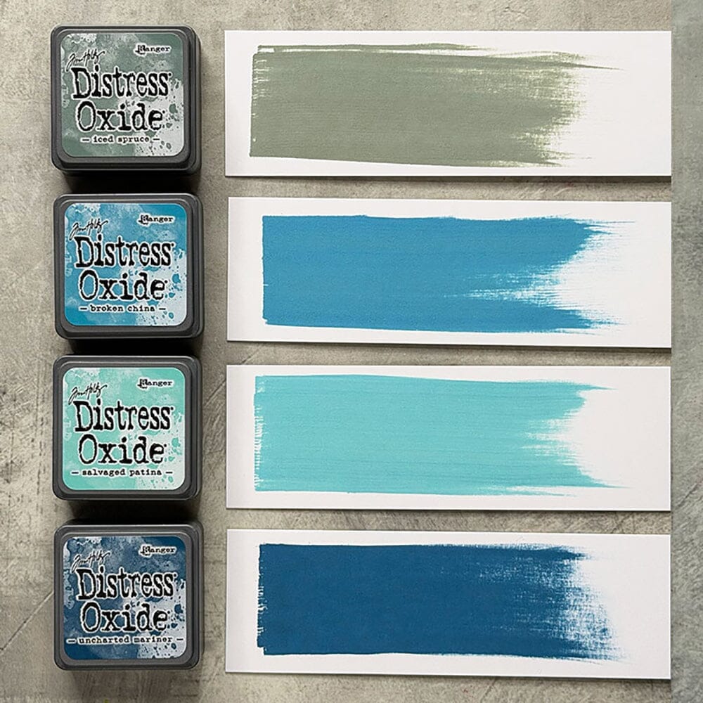 Four Ranger Distress Oxide ink pads from Kit 16 with swatched colours: Iced Spruce, Broken China, Salvaged Patina and Uncharted Mariner, shown on white paper beside each labelled pad.
