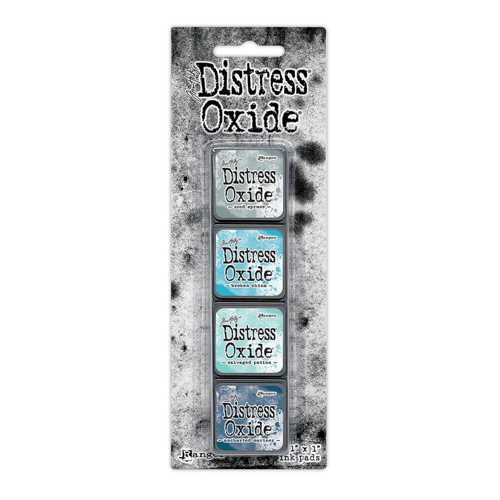 Packaged set of four Ranger Distress Oxide Mini Ink Pads from Kit 16 in Iced Spruce, Broken China, Salvaged Patina and Uncharted Mariner, shown in original Tim Holtz packaging with grungy black-and-white background.
