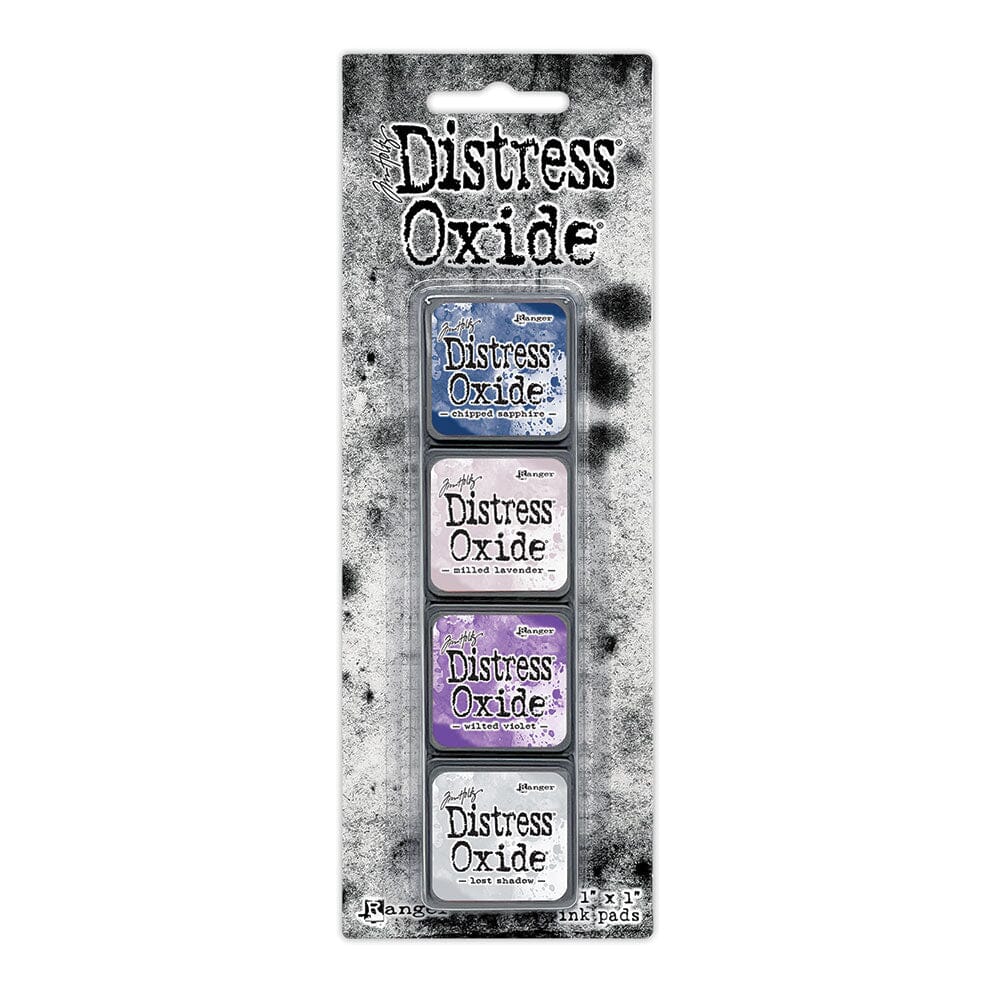 Packaged set of four Ranger Distress Oxide Mini Ink Pads from Kit 17 in Chipped Sapphire, Milled Lavender, Wilted Violet and Lost Shadow, shown in original Tim Holtz packaging with grungy black-and-white background.
