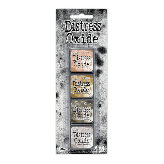Packaged set of four Ranger Distress Oxide Mini Ink Pads from Kit 18 in Tea Dye, Brushed Corduroy, Scorched Timber and Pumice Stone, shown in original Tim Holtz packaging with grungy black-and-white background.
