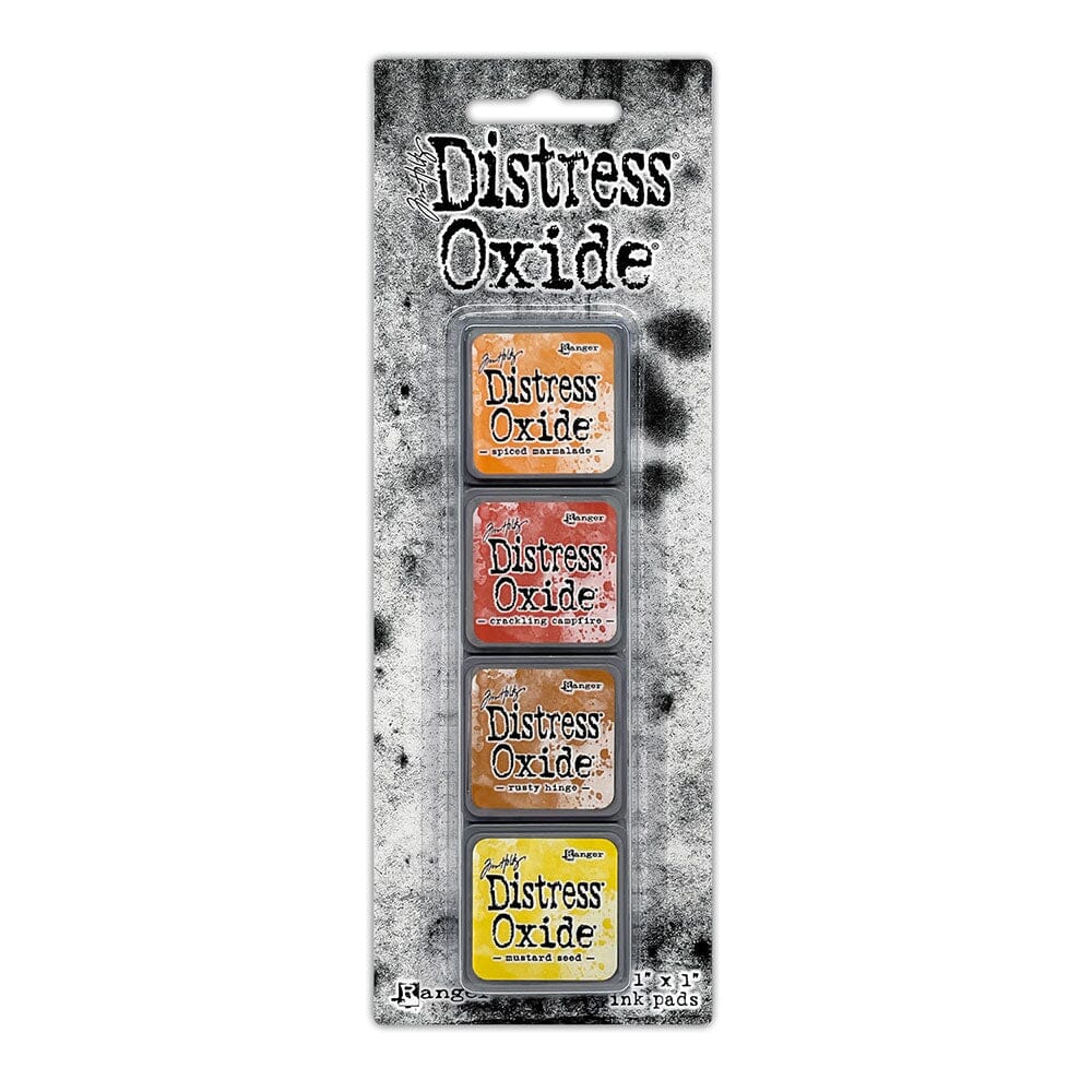 Packaged set of four Ranger Distress Oxide Mini Ink Pads from Kit 2 in Spiced Marmalade, Crackling Campfire, Rusty Hinge and Mustard Seed, shown in original Tim Holtz packaging with grungy black-and-white background.
