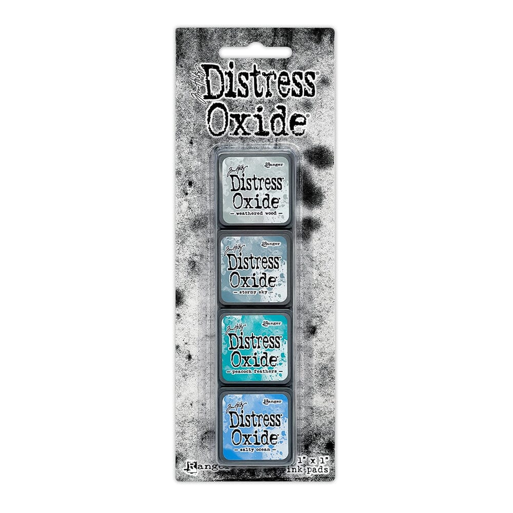 Packaged set of four Ranger Distress Oxide Mini Ink Pads from Kit 4 in Weathered Wood, Stormy Sky, Peacock Feathers and Salty Ocean, shown in original Tim Holtz packaging with grungy black-and-white background.
