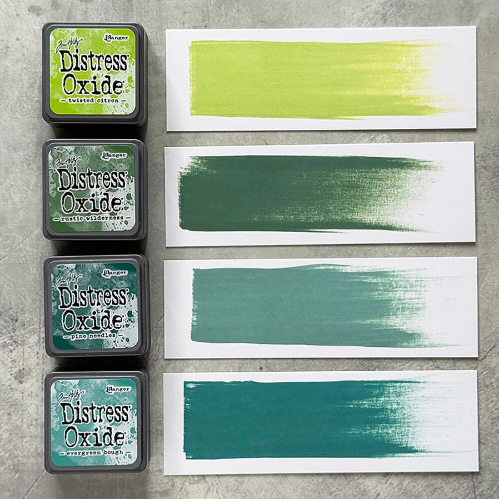 Four Ranger Distress Oxide ink pads from Kit 9 with swatched colours: Twisted Citron, Rustic Wilderness, Evergreen Bough and Pine Needles, shown on white paper beside each labelled pad.

