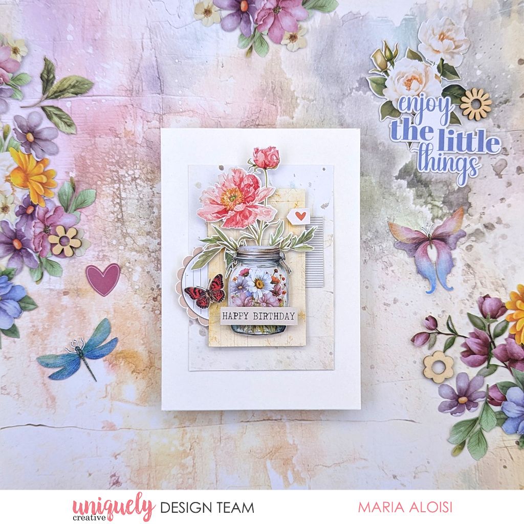 Handmade birthday card by Maria Aloisi using Uniquely Creative Floral Archives collection – features a mason jar filled with layered paper flowers, butterfly and heart embellishments, and a “Happy Birthday” tag. Soft pastel tones and sentiment “enjoy the little things” create a cheerful, nature-inspired design.