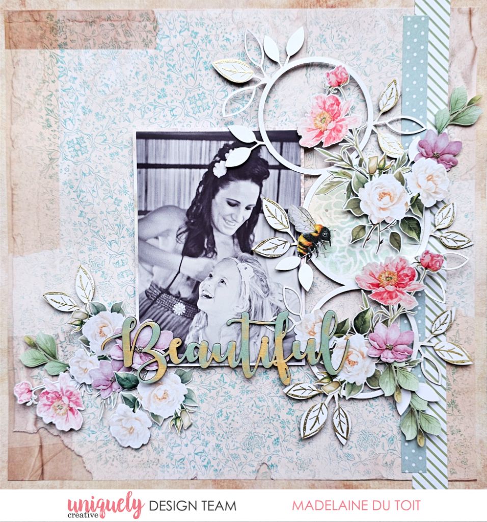 Scrapbook page by Madelaine Du Toit using Uniquely Creative Floral Archives collection – features a joyful black-and-white photo framed by pastel florals, botanical trio overlay, and a colourful “Beautiful” sentiment. Soft layered background and bee embellishment add charm to this heartfelt memory-keeping design.