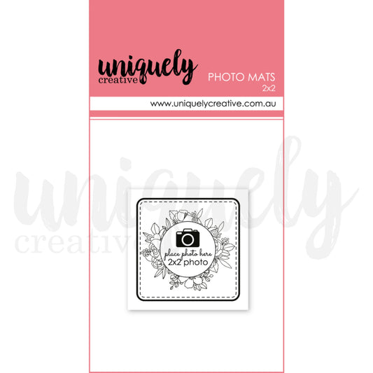 Uniquely Creative 2x2 photo mats pack showing white cardstock mat with floral wreath design and camera icon placeholder for scrapbook layout planning 
