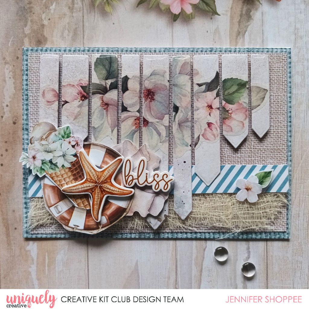 Card sample using Uniquely Creative Beach Sign Die with vertical striped floral panels, shells, starfish, flowers and bliss sentiment on burlap textured background