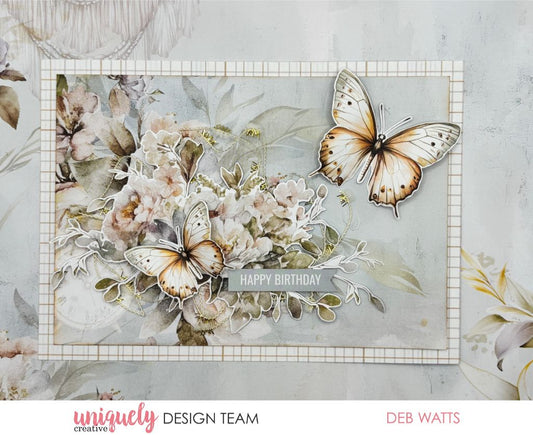 Handmade birthday card by Deb Watts using Uniquely Creative Bohemian Escape collection – features pastel florals, realistic butterflies, and a “Happy Birthday” sentiment on a gray banner. Elegant design with soft botanical layers perfect for celebrating special occasions.