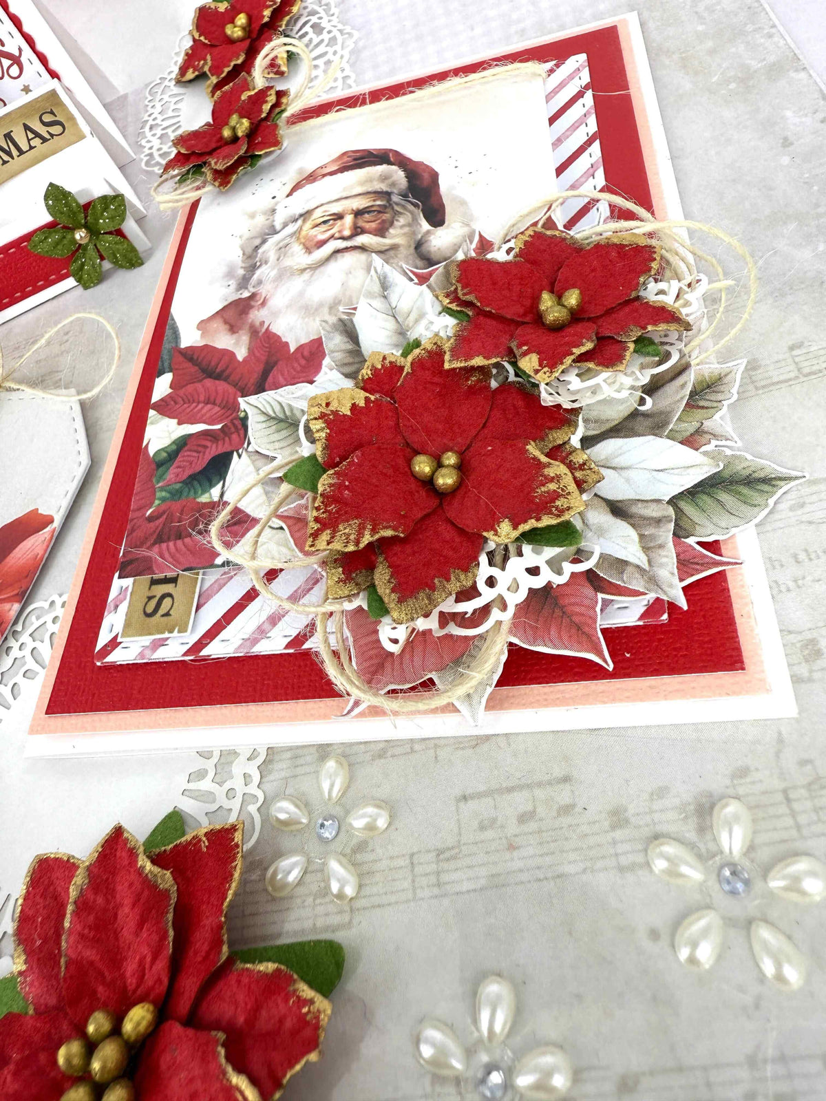Handmade Christmas card decorated with red and gold layered poinsettia flower embellishments