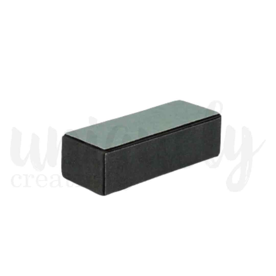 Uniquely Creative black rectangular sanding block with a grey abrasive surface 