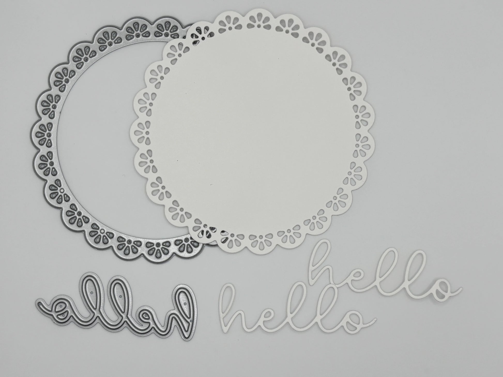 White die-cut doily frames and script hello sentiments in outline and solid versions showing the Uniquely Creative Delicate Doily Die cutting results