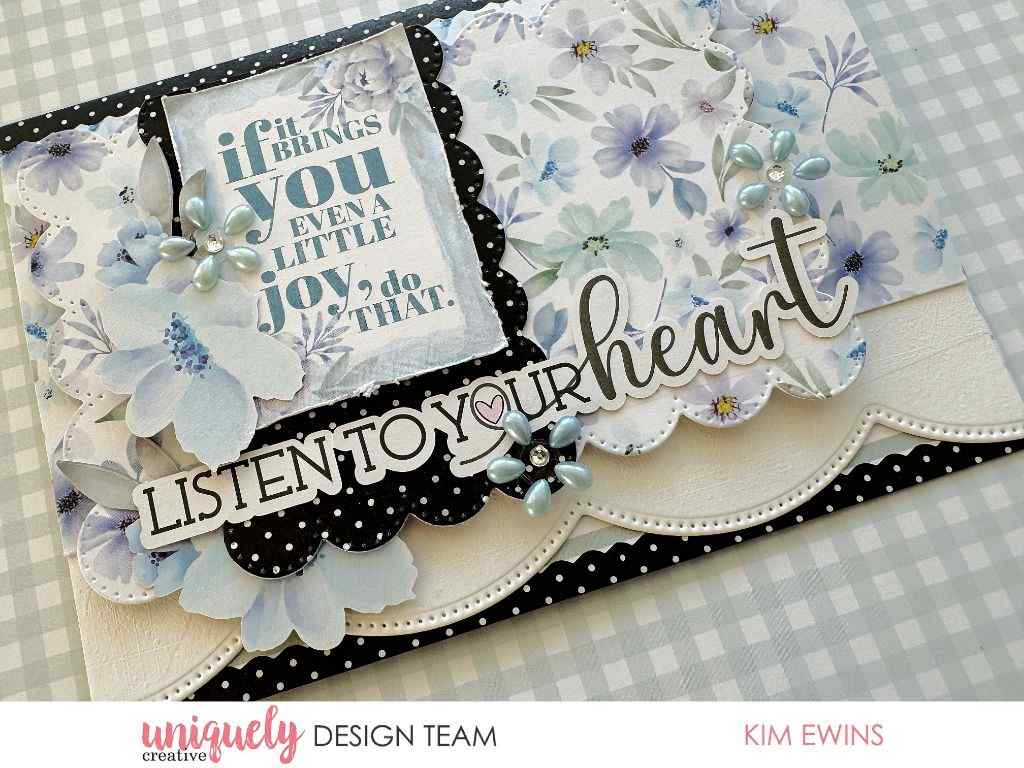 Handmade card sample featuring two pale-blue pearl daisy embellishments with rhinestone centres on a floral card with black-and-white scalloped layers and a “listen to your heart” message.