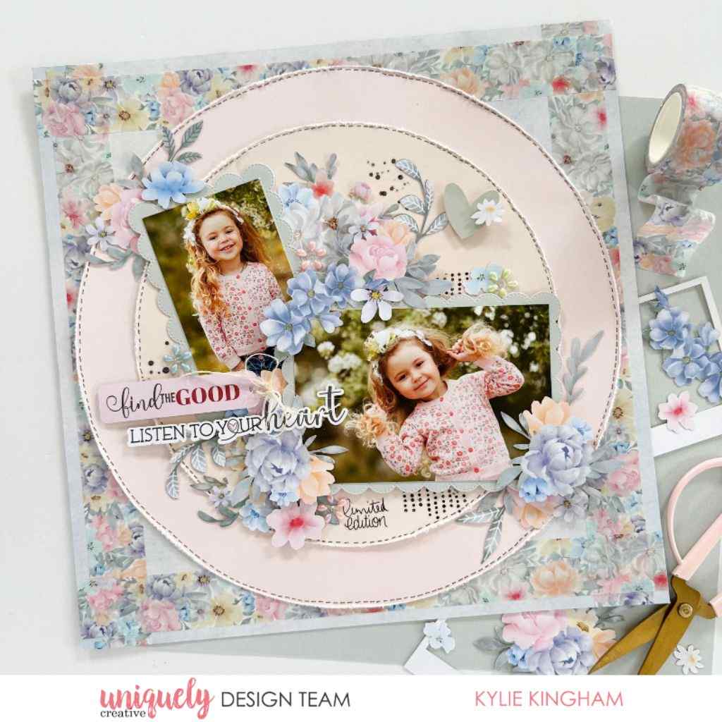 Scrapbook layout sample featuring two photos of a smiling child on a pale pink circular base, with blue and pink floral embellishments and patterned paper.