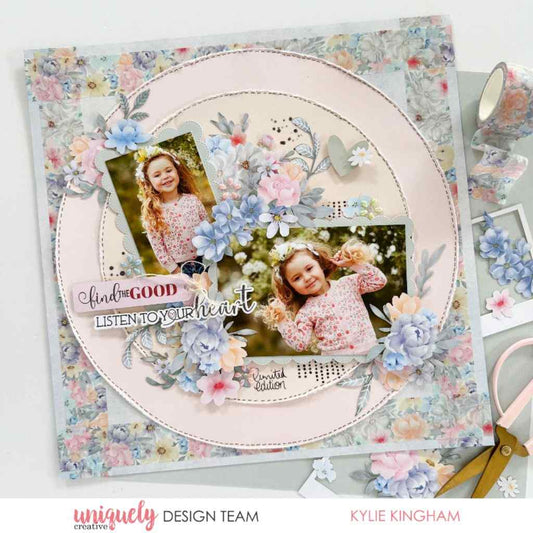 Scrapbook layout sample featuring two photos of a smiling child on a pale pink circular base, with blue and pink floral embellishments and patterned paper.