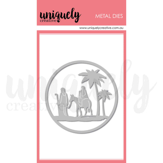 Uniquely Creative Nativity Scene Die, a single metal cutting die featuring a circular framed silhouette of Mary riding a donkey led by Joseph with two palm trees, approximately 3½" × 3½"