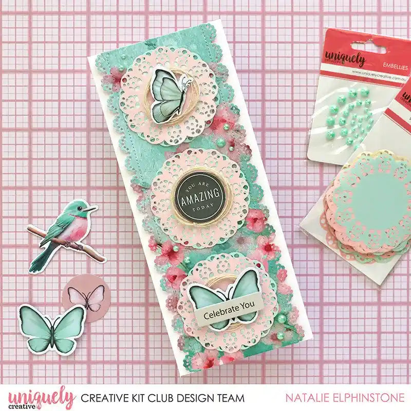 Handmade greeting card featuring a pastel doily layered with die-cut flowers and coordinating paper embellishments