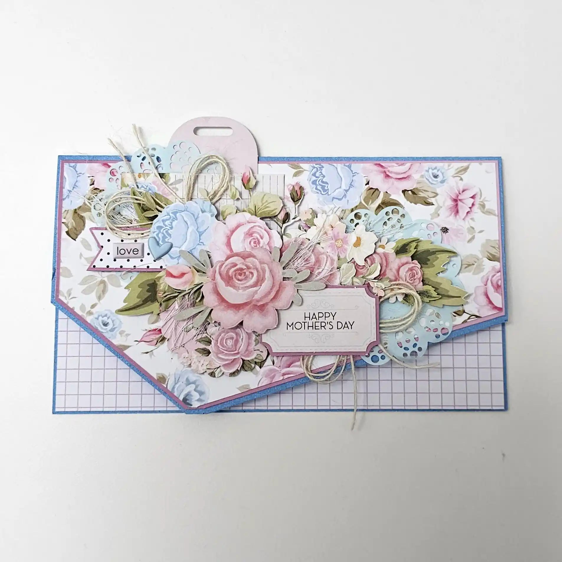 Handmade card decorated with a pastel paper doily, layered floral embellishments and a stamped "Happy Mother's Day" sentiment