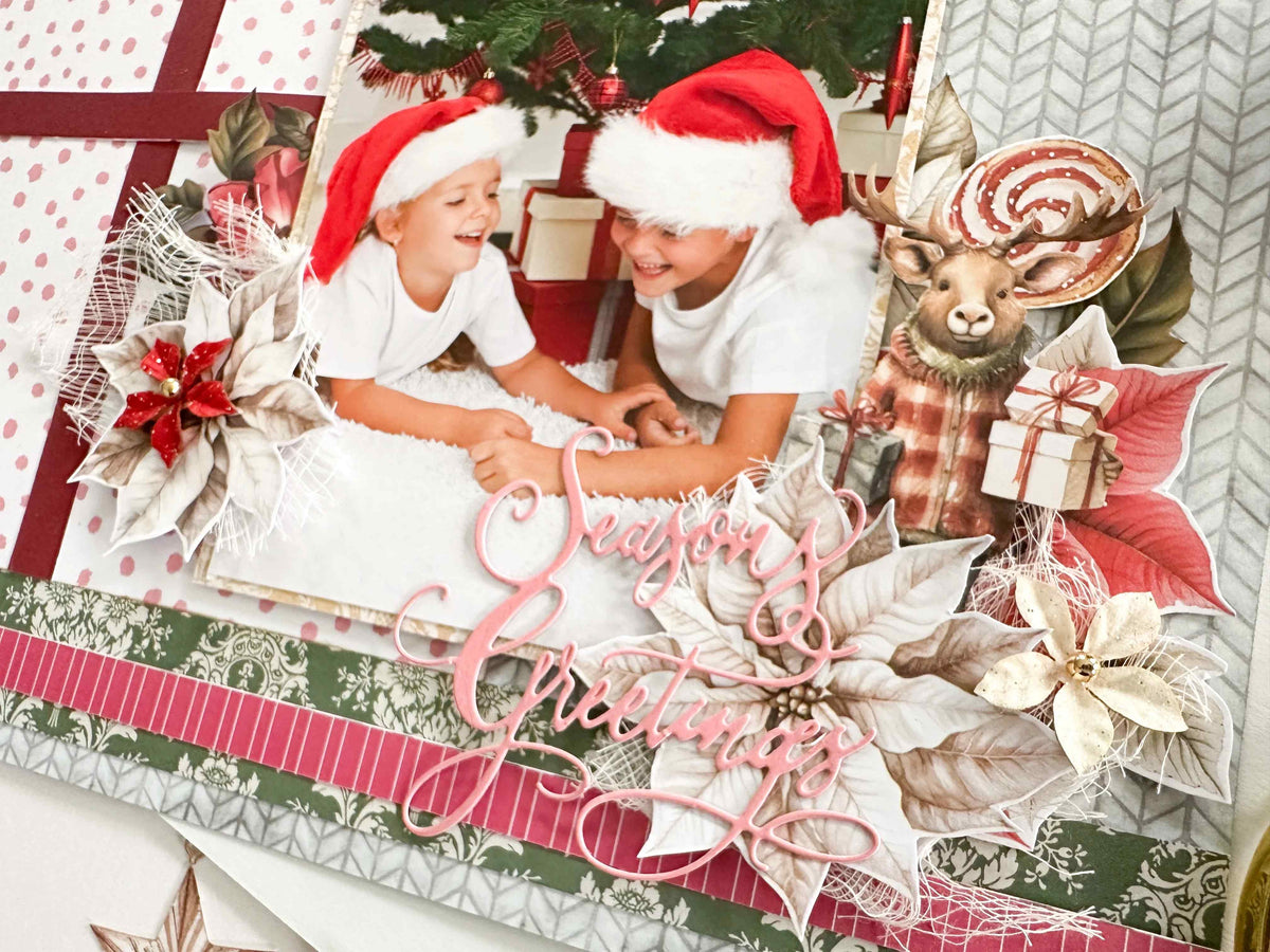 Christmas scrapbook layout with a photo of two children in Santa hats, poinsettias and the Season's Greetings die cut sentiment