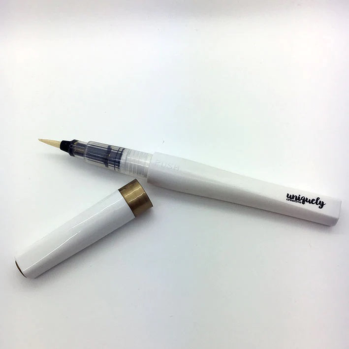 Uniquely Creative Gold Sparkle Brush with cap removed, showing fine brush tip with gold pigment