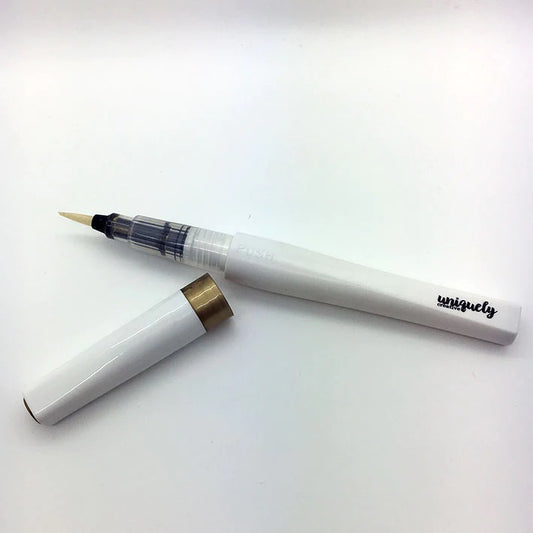 Uniquely Creative Gold Sparkle Brush with cap removed, showing fine brush tip with gold pigment