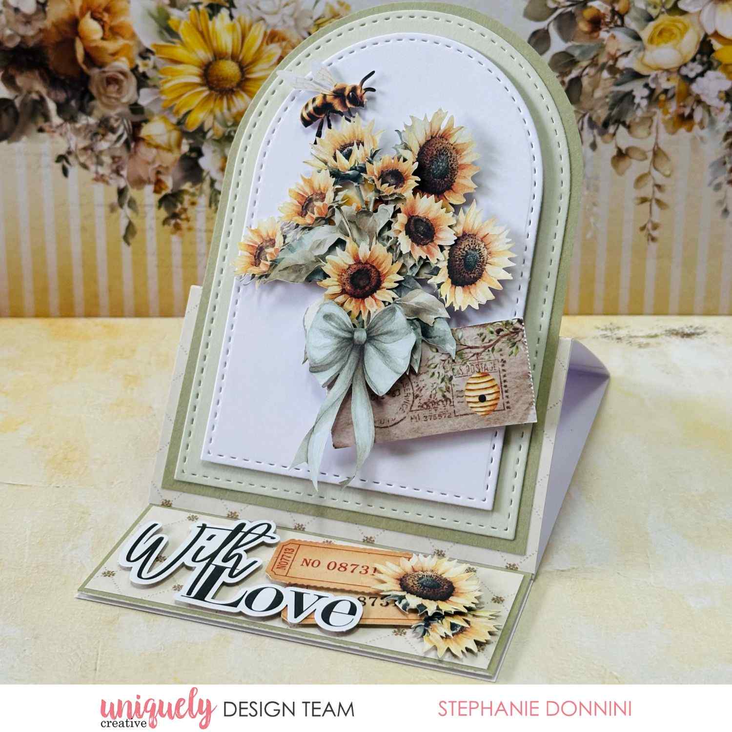  Uniquely Creative Sweet As Honey easel card with arched panel, sunflower bouquet, bee, sage bow, vintage ticket ephemera, and "With Love" sentiment, created by Stephanie Donnini