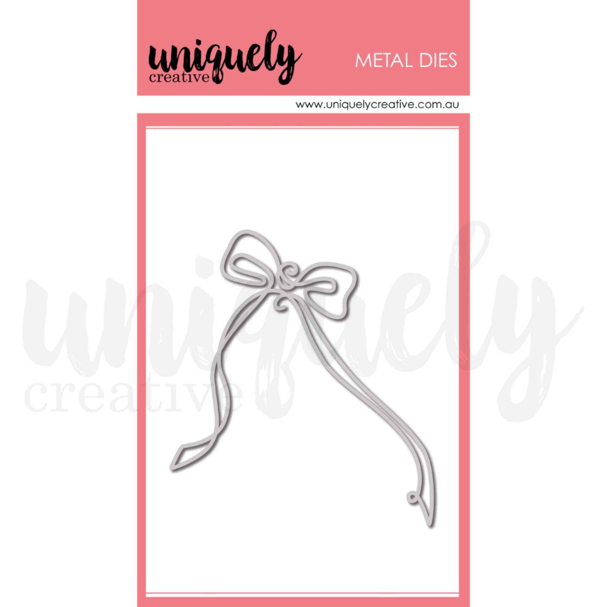 Uniquely Creative The Finishing Touch Bow Die metal die showing a delicate outline bow with decorative swirl centre and two long sweeping ribbon tails that curl at the ends, approximately 4 by 3 and a half inches
