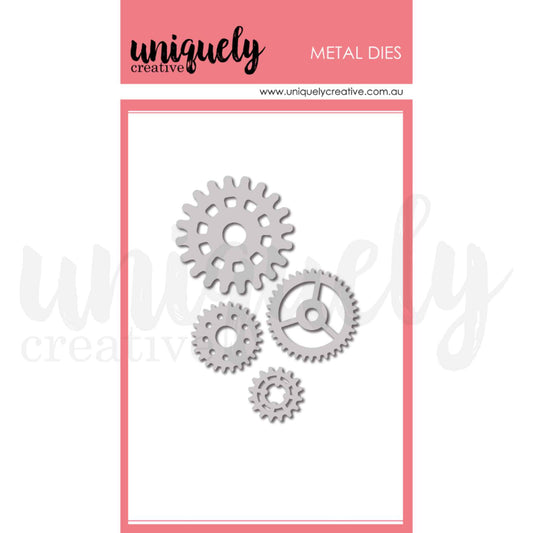 Uniquely Creative Cogs Die UCD2241 metal die set showing four gear cog dies in sizes approximately 3/4 inch, 1 inch, 1.5 inch and 1.75 inch including a detailed spoked wheel cog design