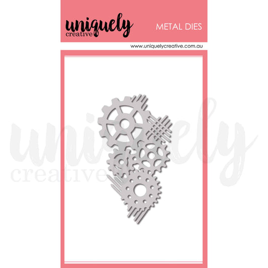 Uniquely Creative Cogs Texture Die UCD2242 metal die approximately 2.25 by 3.75 inches showing a cluster of three interlocking gear cogs with speed line accents