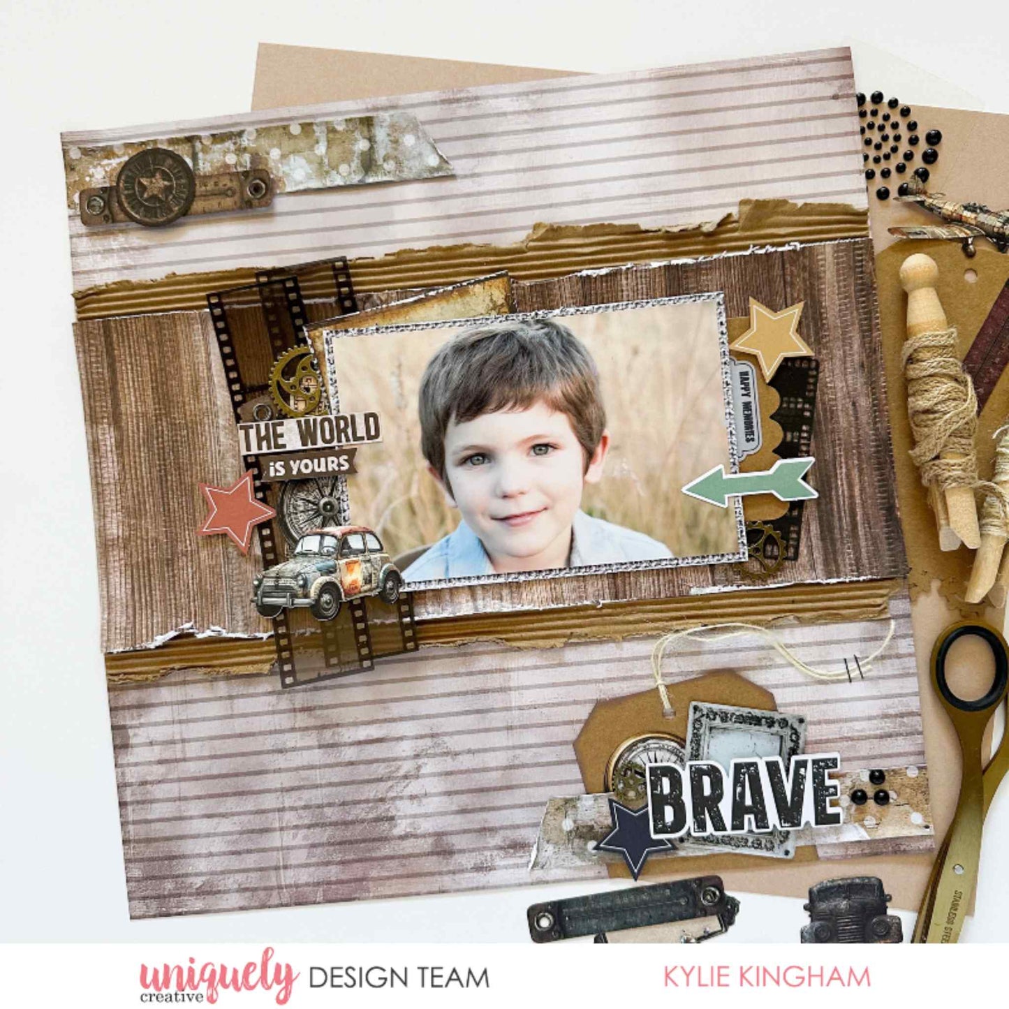 Scrapbook layout using Uniquely Creative Wings and Wheels paper, featuring boy's portrait with Brave title, film strip, vintage car, stars and arrow embellishments on wood grain background