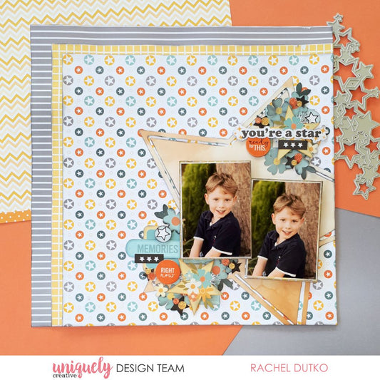 You're a star scrapbook layout with two photos using Uniquely Creative Written in the Stars collection featuring star pattern paper in orange and grey, mixed embellishments, floral clusters and Memories sentiment