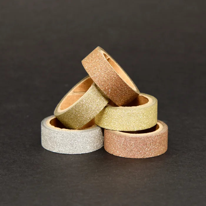 Stack of glittery tape rolls on a dark background